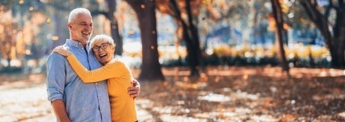 Older couple embracing in a fall forest