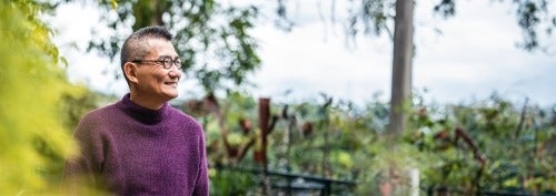 older man in purple sweater looking at nature